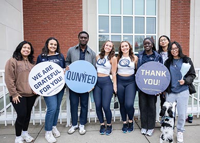 Students holding thank you signs