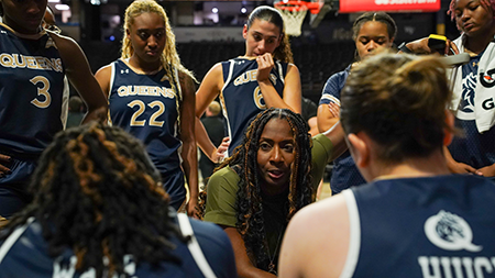 Women's basketball coach huddling with players