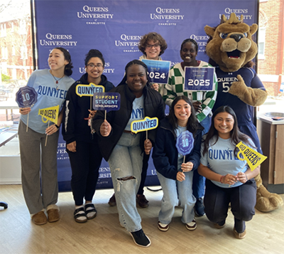 Students celebrating QUnited with Rex mascot
