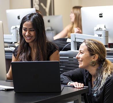 Student and professor working on laptop