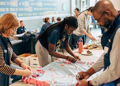 Staff and student making blankets for Royal Days of Service