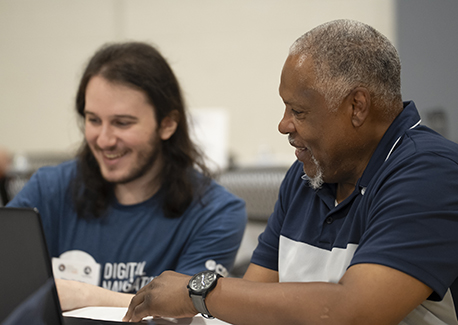 Two men working on a laptop