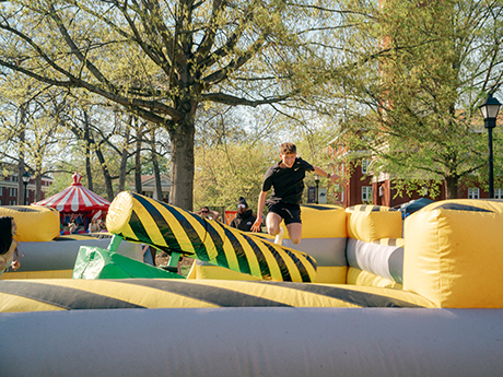 Student jumping in bouncy obstacle course