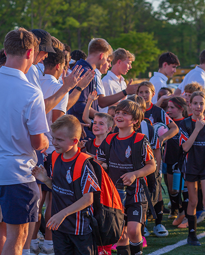 Soccer camp kids high-fiving coaches