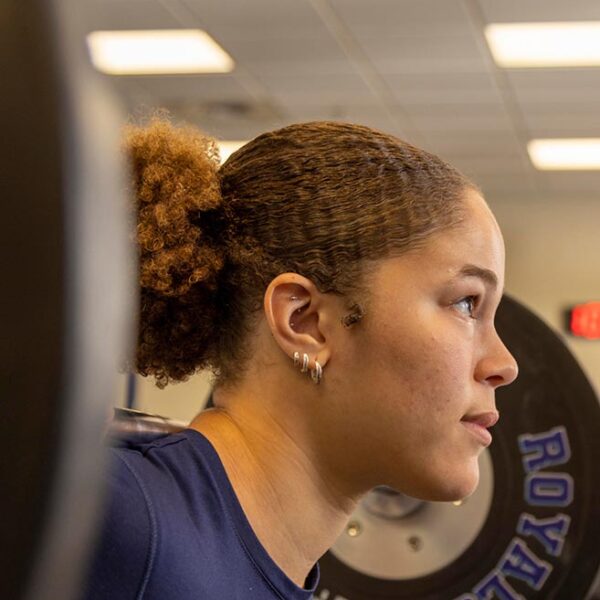 Student lifting weights in gym